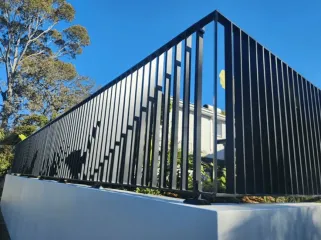 Black aluminium slat fencing around a corner