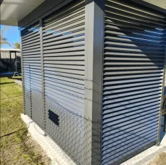 Grey horizontal aluminium louvre fencing with brick pier