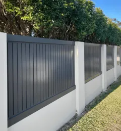 White vertical aluminium slat fencing on a rendered wall